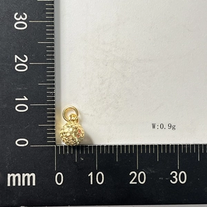 Detail showing an 8mm gold sphere pendant with textured finish and measurement on ruler