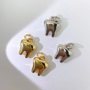 Detailansicht polierter zahnförmiger Anhänger in Gold und Silber für Schmuck-DIY-Zubehör