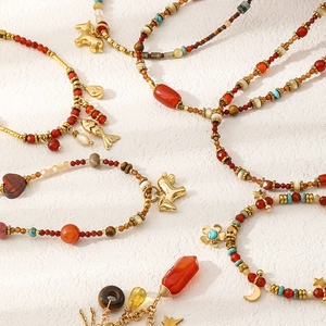 Detalle de collares de cuentas hechos a mano con ágata roja, turquesa y colgantes de caballo