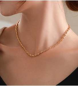 Nahaufnahme einer minimalistischen goldenen Gliederkette am Hals eines Models