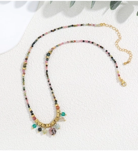 Detalle de collar bohemio de cuentas coloridas con colgantes de piedra natural y espaciadores