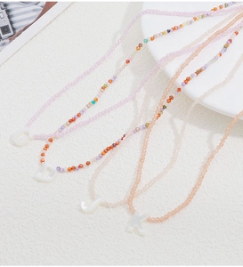 Dettaglio della collana di perline di cristallo colorato con ciondoli a lettere G D J K