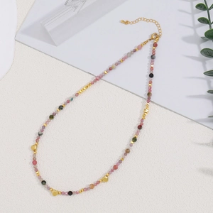 Collar artesanal de turmalina con cuentas coloridas y colgantes de corazón dorado en blanco