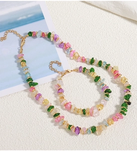 Detail view of colorful irregular natural stone beaded necklace and bracelet set with gold clasp
