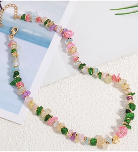 Close-up of colorful irregular natural stone beaded necklace with gold spacers and lobster clasp