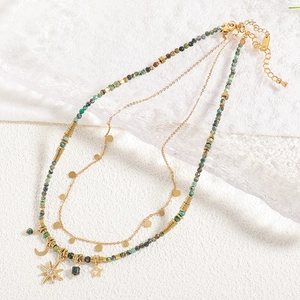 Collana boho multistrato di perline con ciondoli a stella su sfondo marmo bianco