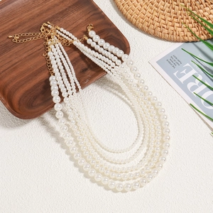 Elegante meerlaagse parelketting van imitatieparels met gouden sluiting op dienblad
