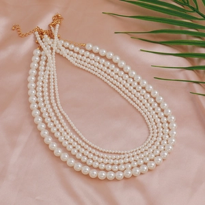 Elegante gelaagde faux parelketting met gouden sluiting op zijdeachtige ondergrond