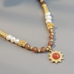 Ethnic pearl necklace with sun pendant, natural stones and gold beads in retro style