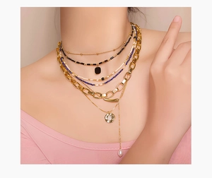 Detalle de collares de varias capas chapados en oro de 18 quilates con cuentas en una modelo
