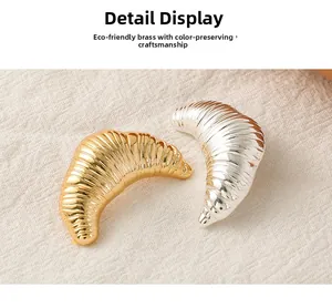 Detail of silver and gold croissant brooches crafted in premium eco-friendly brass material