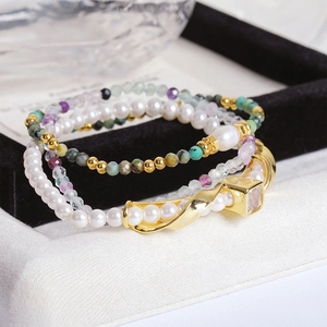 Detalle del conjunto de pulseras de perlas y piedras de colores con toques dorados