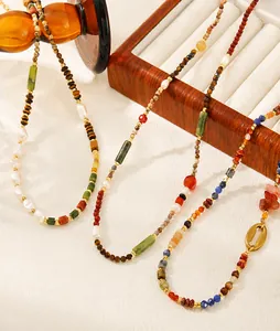 Detail of vintage necklace with tiger eye stones, freshwater pearls, and golden beads