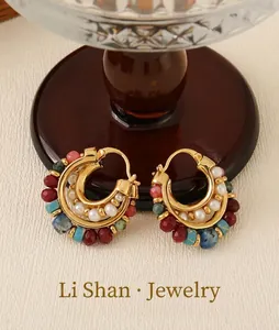 Close-up of vintage French C-shaped earrings with colorful beads and faux pearls