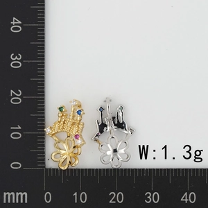 Macro detail of micro-paved zircon castle charms in gold and silver with size scale