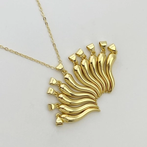 Polished gold chili pepper necklace set with lucky cornicello pendants on white background