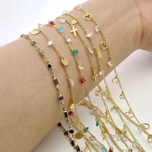 Detailed close-up of gold plated multi-color zircon charm bracelets on model wrist