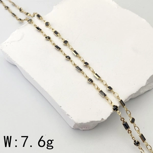Detail of a 7.6g gold chain necklace with square and round black zircon stones on stone