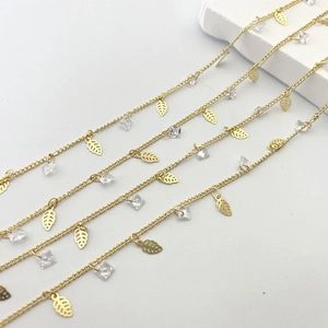 Detail of gold chain with hollow leaf charms and clear square crystals for jewelry DIY