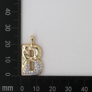 Detailed macro view of gold letter B pendant with zircon stones and textured metal finish