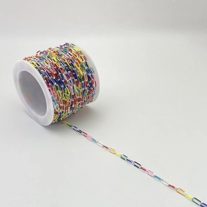 Detailed macro view of colorful enamel square link chains on a spool for DIY jewelry crafts