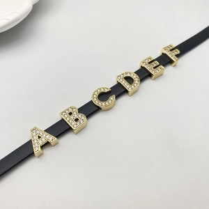 Detail of DIY jewelry strap with gold plated A-F letter sliders and white rhinestones