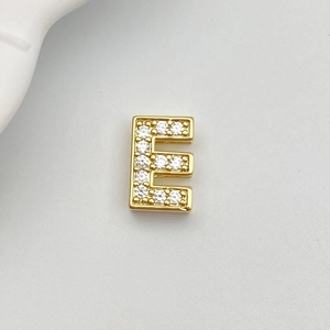 Detailed view of a gold-plated letter E pendant with white cubic zirconia pavé stones