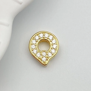 Macro shot of gold-plated charm with micro-paved white zircons for DIY jewelry making