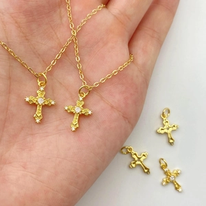 Détail du pendentif croix dorée avec zircons micro-incrustés et motifs en relief rétro