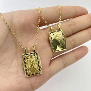Gros plan de pendentifs tarot dorés avec zircons noirs et motif de lune céleste