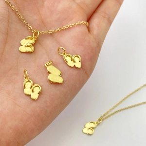 Gros plan sur un pendentif tongs dorées avec une finition polie miroir élégante