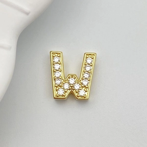 Detailed close-up of a gold-plated letter W charm with micro-pave white zircon stones