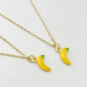 Gros plan de jolis pendentifs banane 3D sur chaînes dorées pour colliers DIY