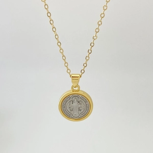 Detail of Saint Benedict medal pendant featuring a two-tone gold and silver religious icon