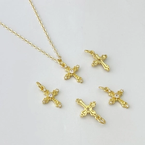 Gros plan du pendentif croix dorée avec micro-zircons et motifs ajourés élégants