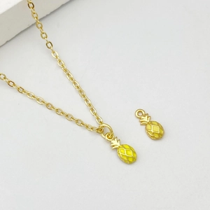 Gros plan de pendentifs ananas jaunes avec texture quadrillée sur collier doré