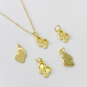 Détail de pendentifs tongs dorés sur une fine chaîne de collier Bohème