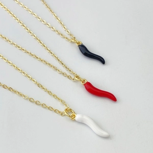 Detail of Cornicello horn pendant necklaces in black, red and white with gold chains