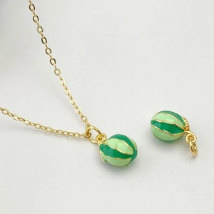 Vue détaillée du pendentif fruit en émail vert avec chaîne dorée pour bijoux DIY