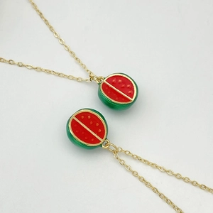 Détail de colliers avec pendentif pastèque réaliste en émail rouge et chaîne dorée