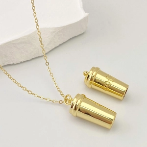 Vue détaillée d'un collier avec pendentif tasse à café doré et gravure COFFEE chic