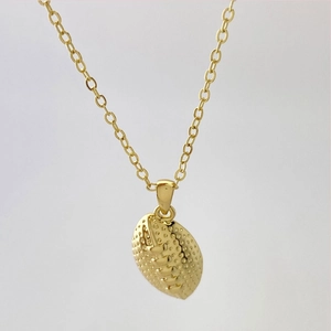 Macro shot of gold american football pendant showing realistic texture and stitch detail