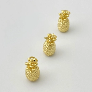 Détail macro de pendentifs ananas dorés avec texture de fruit réaliste pour bijoux DIY