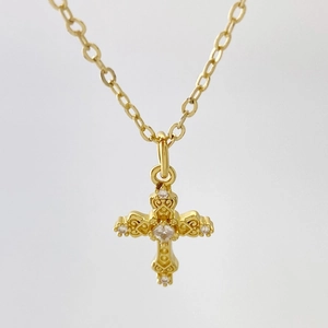 Macro du pendentif croix en or avec micro-pavage en zircone et sculpture vintage ajourée