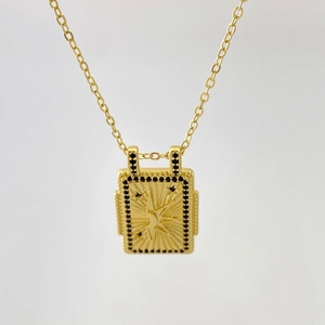 Détail du collier à pendentif rectangulaire doré avec motif étoile et pierres noires