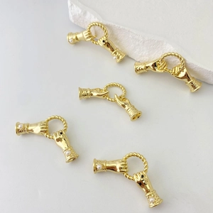 Dettaglio di cinque connettori per gioielli dorati a forma di mani con perle e pietre