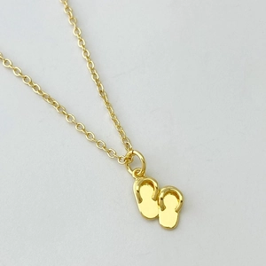 Collier bohème plaqué or avec un pendentif tongs serti pour un style estival chic