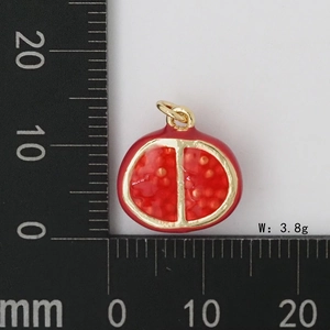 Vue macro du pendentif grenade avec émail rouge et métal doré pesant 3,8g