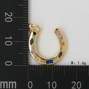 Détail macro du pendentif fer à cheval avec sept zircons colorés et finition or poli