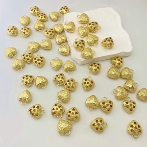 Detailed view of gold heart charms with hammered texture and hollow patterns for jewelry DIY